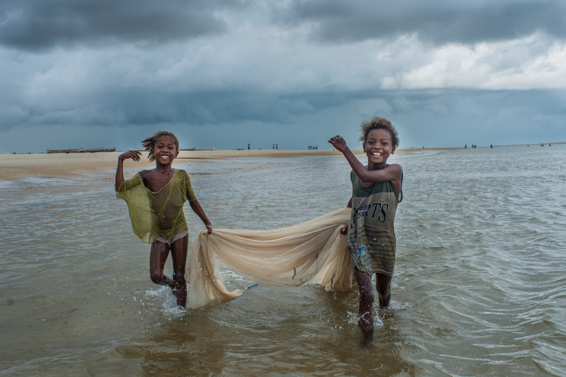 Girls from the nomadic Vezo tribe drag their net through the shallows, hoping to bring home some fish for supper. Madagascar.